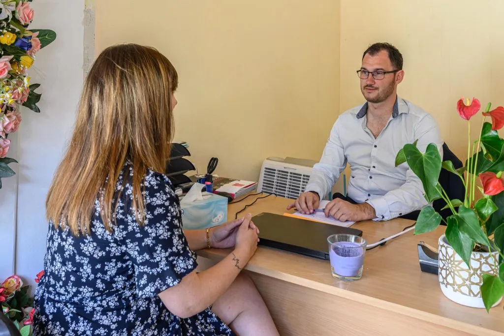 Conseiller funéraire en entretien dans son bureau accueillant une cliente